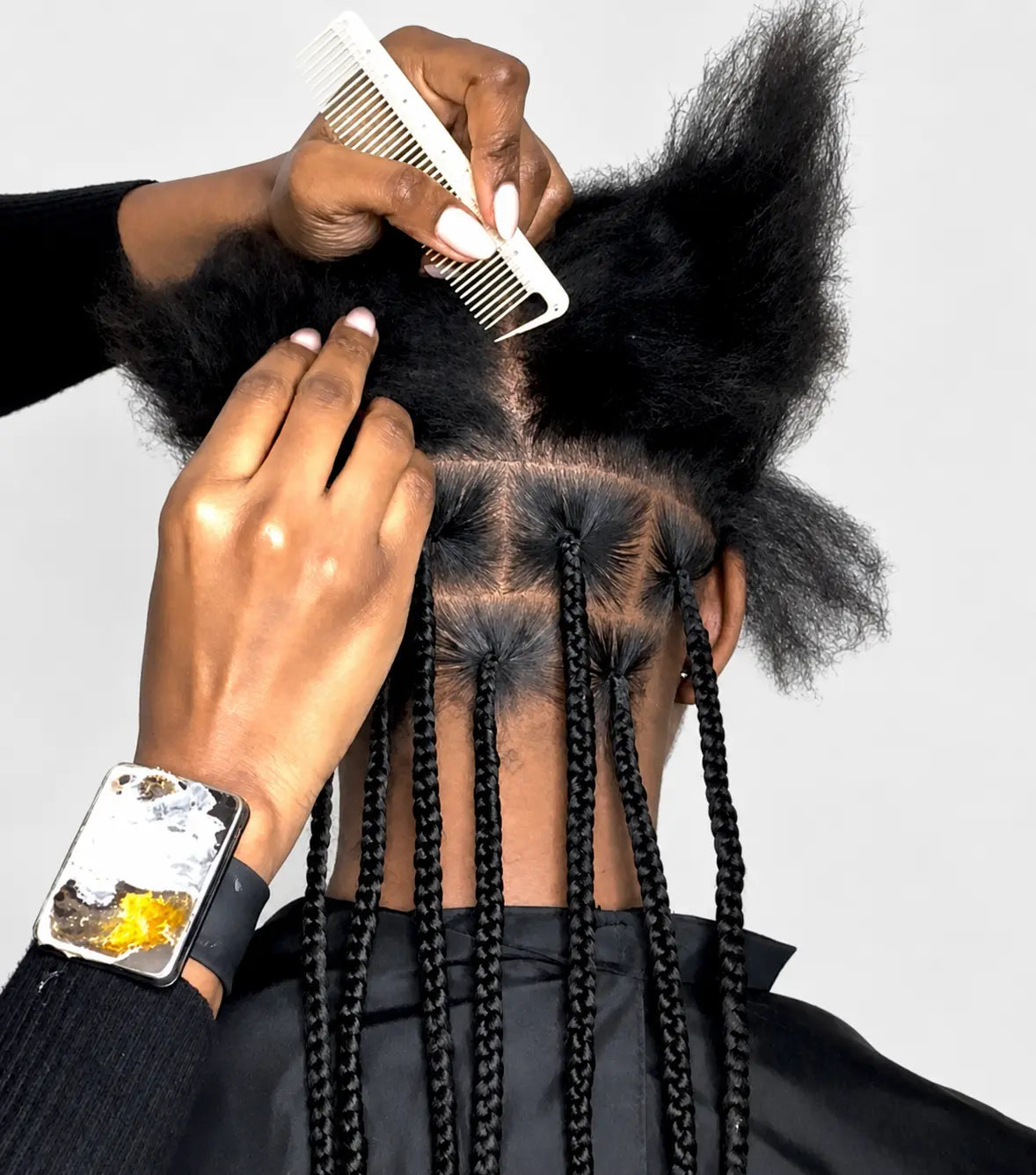 Person parting hair with a white comb on a plain background